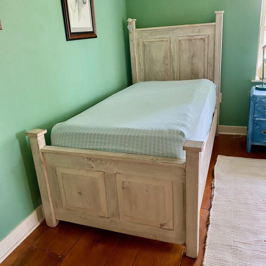 Twin bed finished in white paint